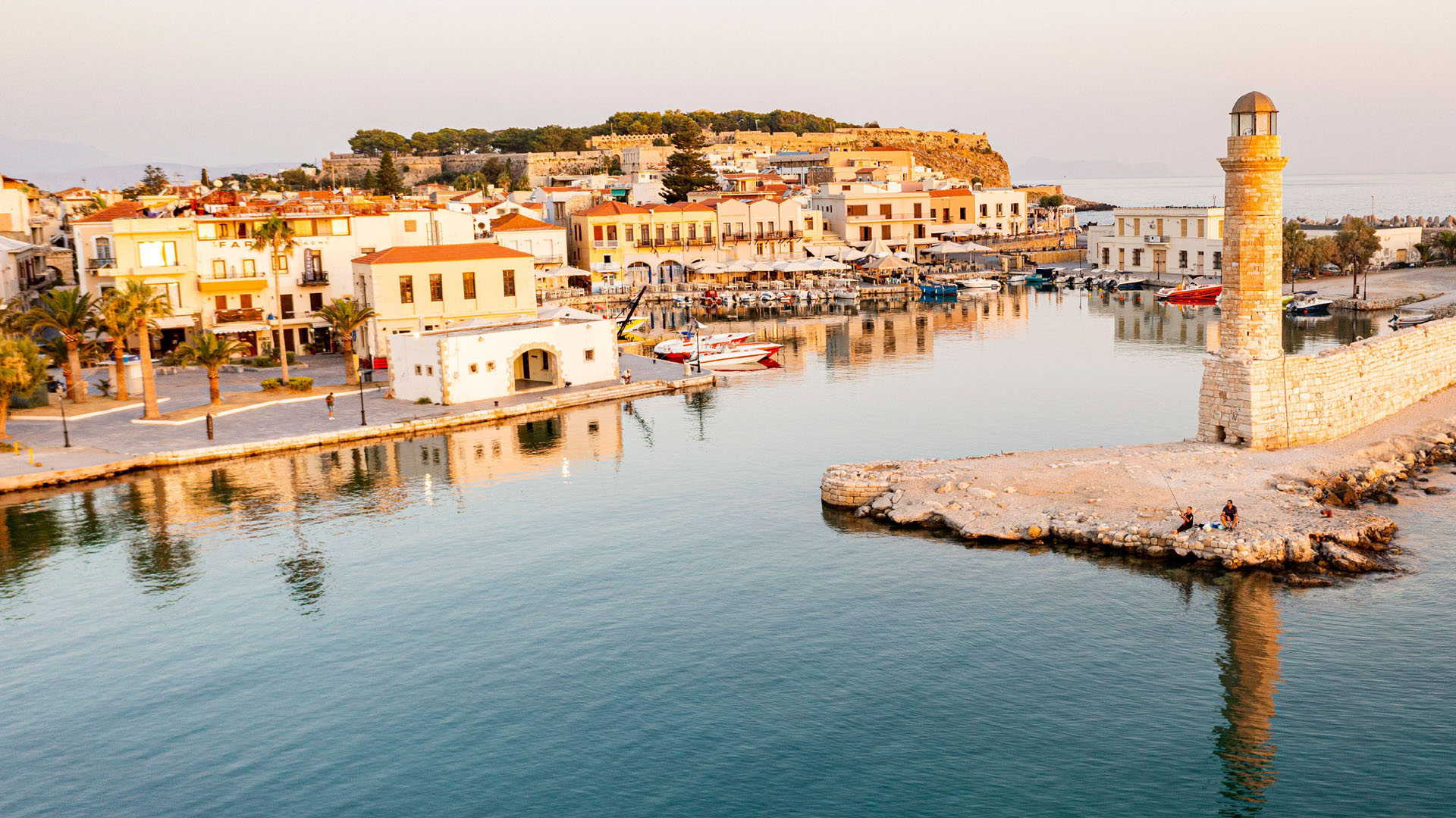 Aerial view of the calm sea at dawn surrounding the old Venetian port and lighthouse, Rethymno, Crete island, Greek Islands, Greece, Europe